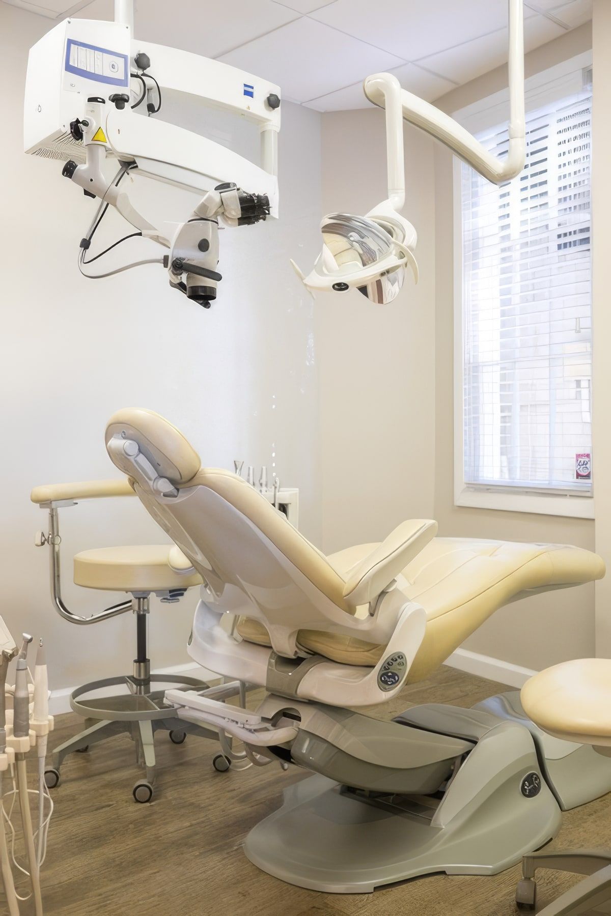 A treatment room with the dental chair and the surgical microscope mounted above it